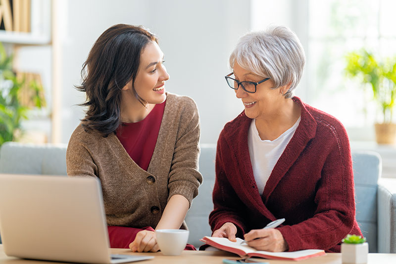 The Oaks at Bartlett | Senior woman writing notes with caregiver