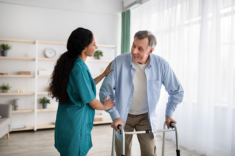 The Oaks at Bartlett | Medical professional helping senior man walk