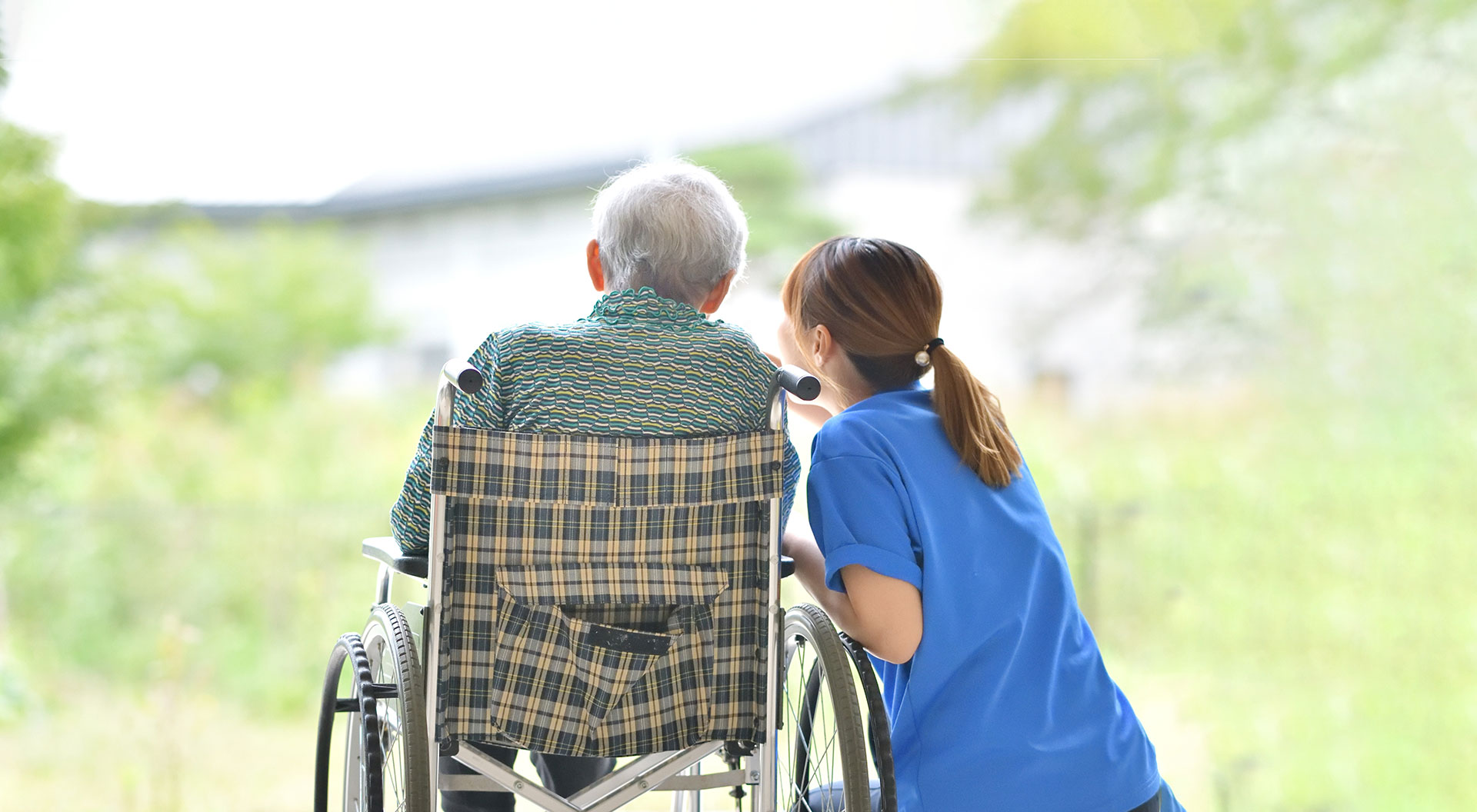 The Oaks at Bartlett | Senior man in wheelchair looking at scenic view with caregiver