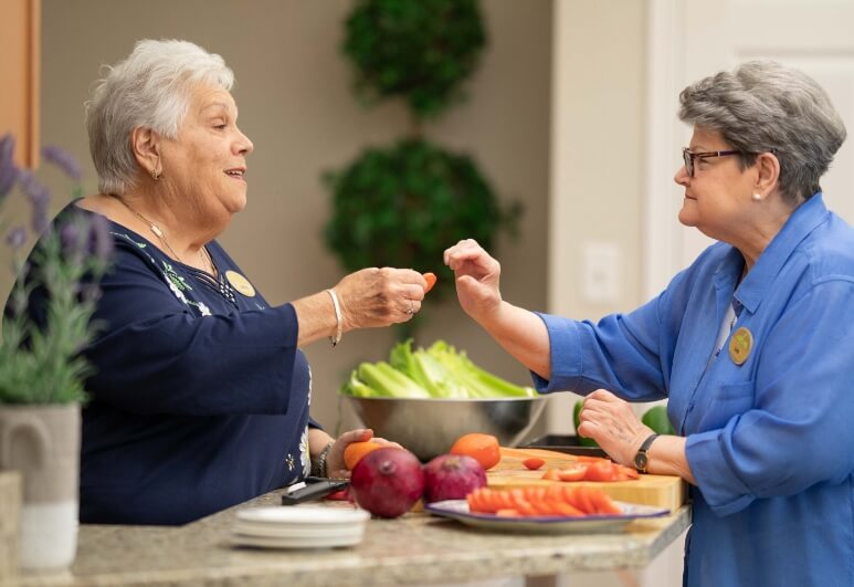 The Oaks at Bartlett | Two seniors socializing while preparing a lunch