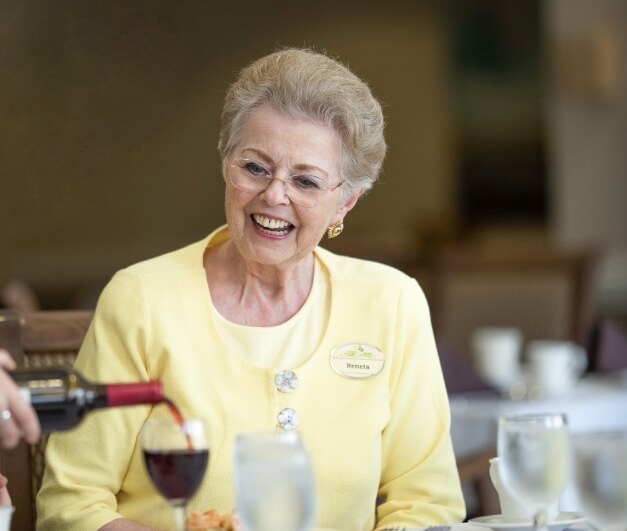 The Oaks at Bartlett | Happy senior smiling while wine is being poured