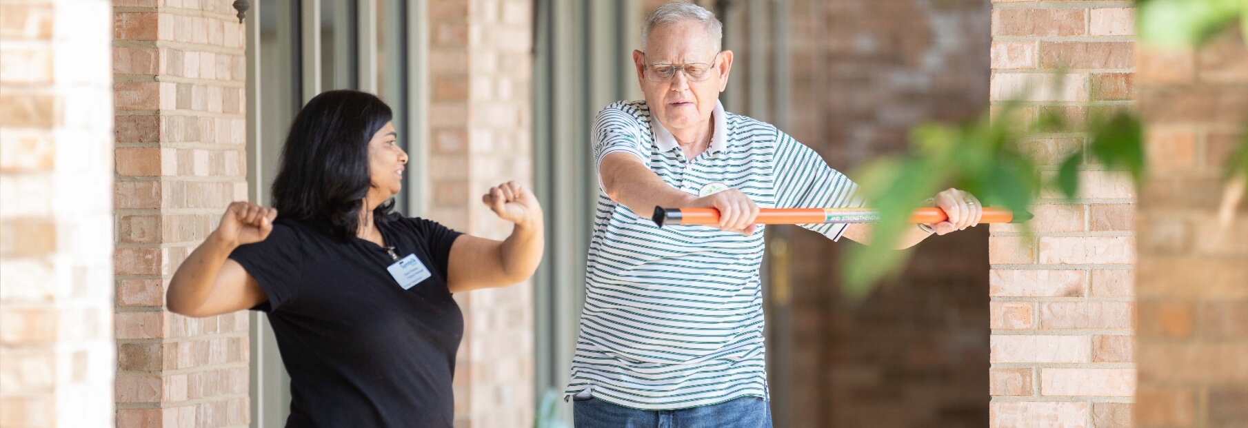 The Oaks at Bartlett | Senior exercising with caregiver outside