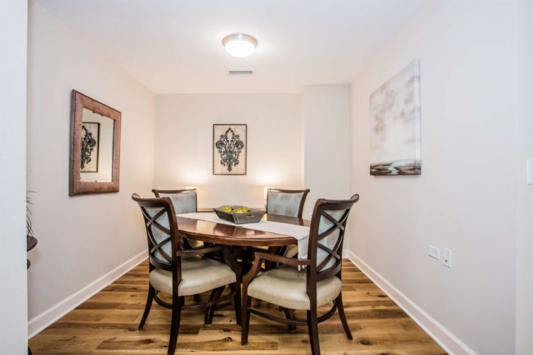 a dining room with hardwood floors and a picture on the wall.