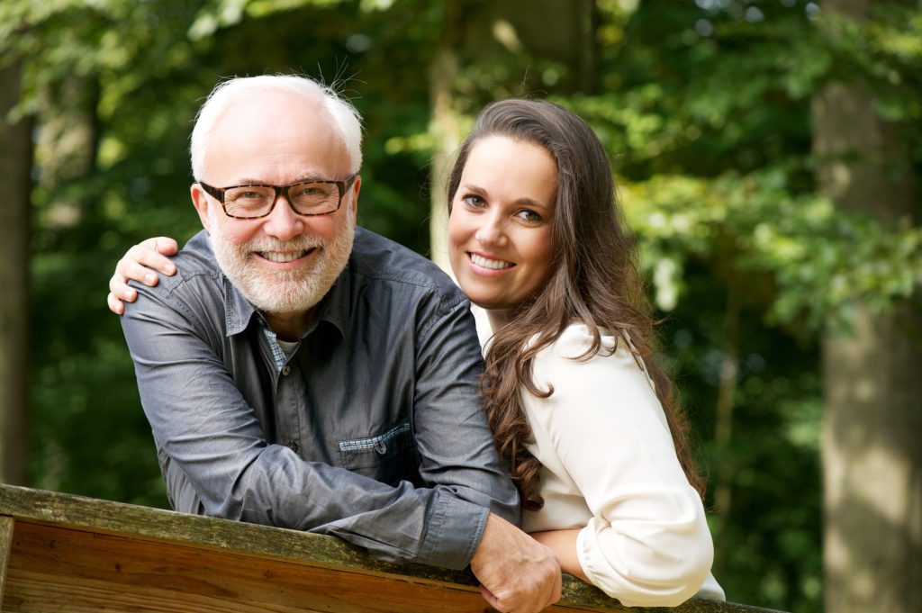 Happy mature man smiling with young woman